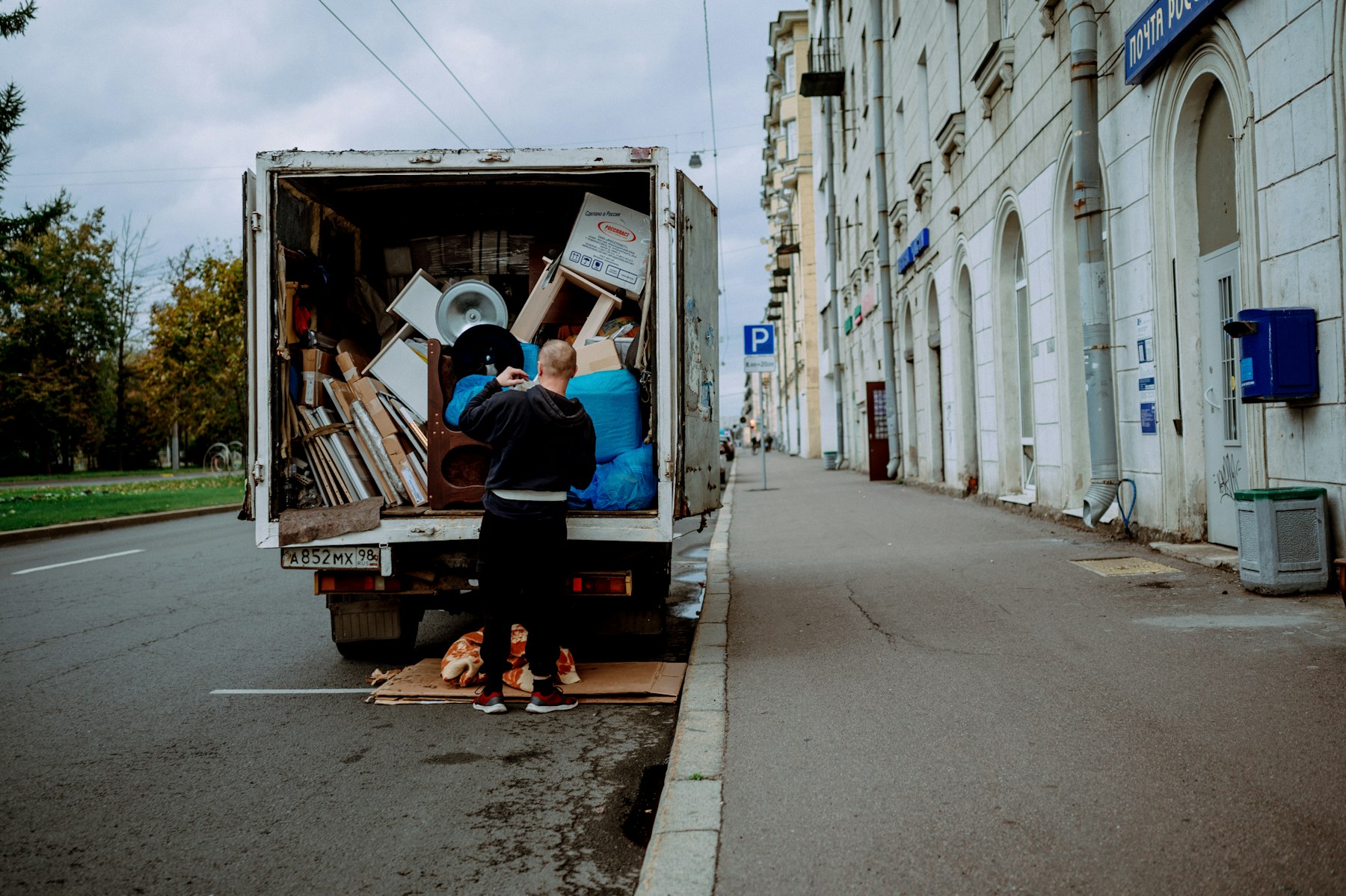 A worker loading household furniture into a removal truck.